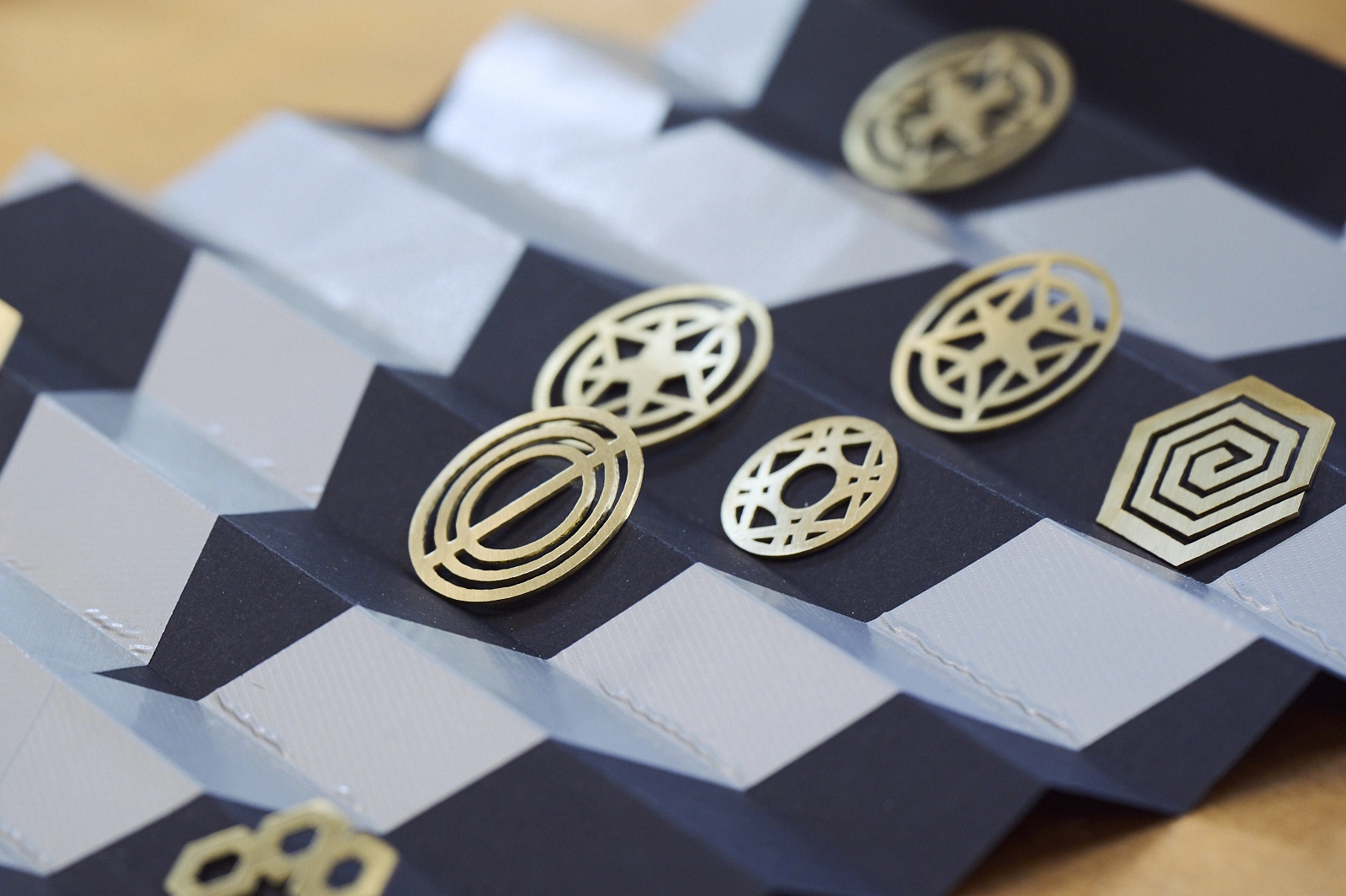 bijoux plats et rond disposés sur un papier cartonnée bleu et blanc